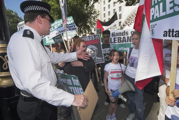 Policeman asks child not to use megaphone in prohibited zone, Westiminster, July 2006 (C) Peter Marshall, 2006.